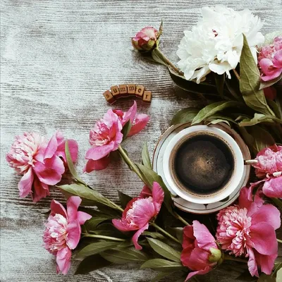 Чашка кофе с цветами и цветок на столе | Премиум Фото